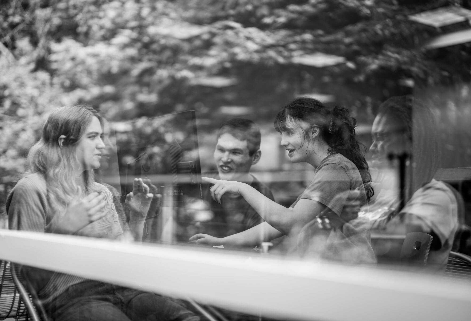 Photo outside of LOH 120 looking through a window of consultants talking together